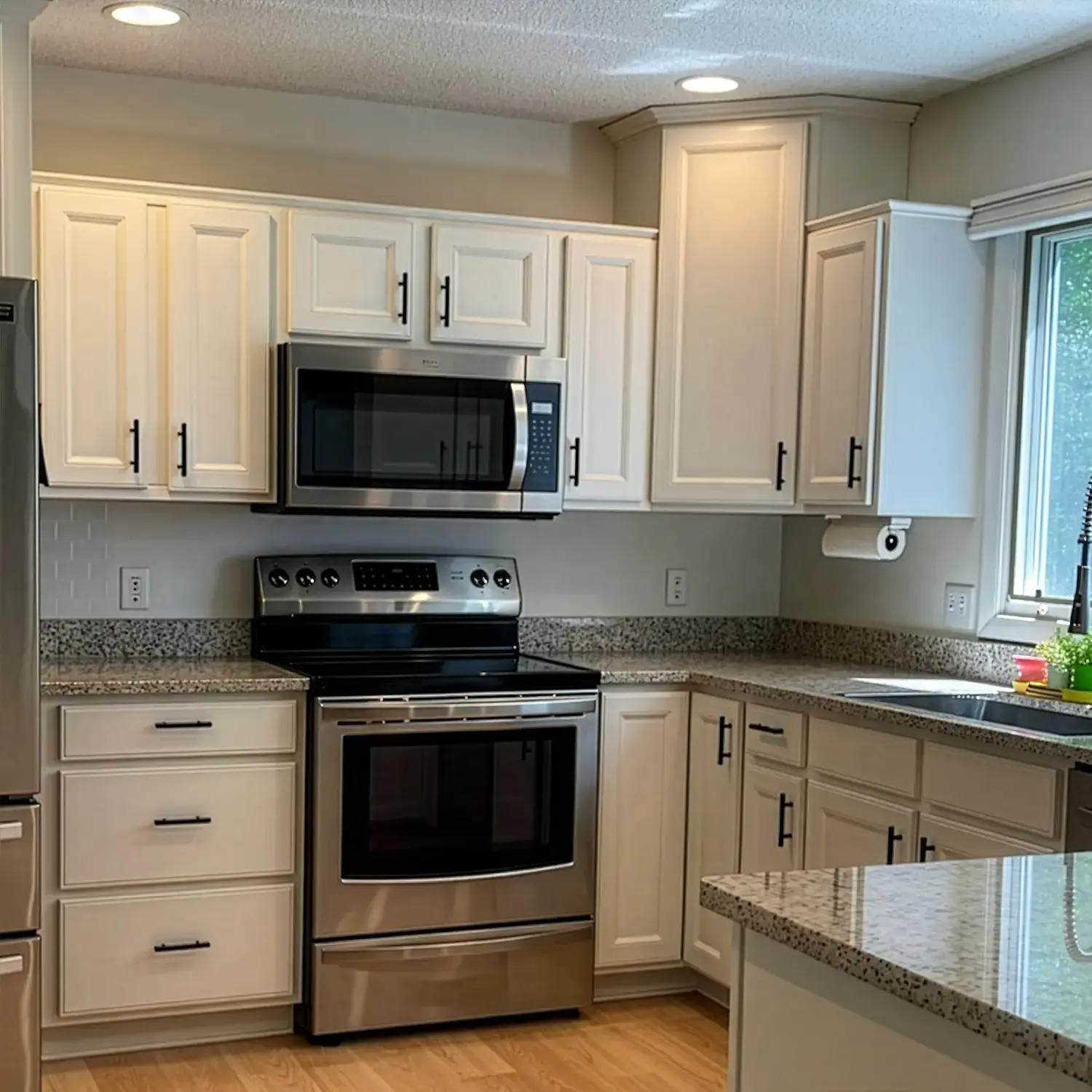 Kitchen cabinets refinished to clean white finish with modern look after painting