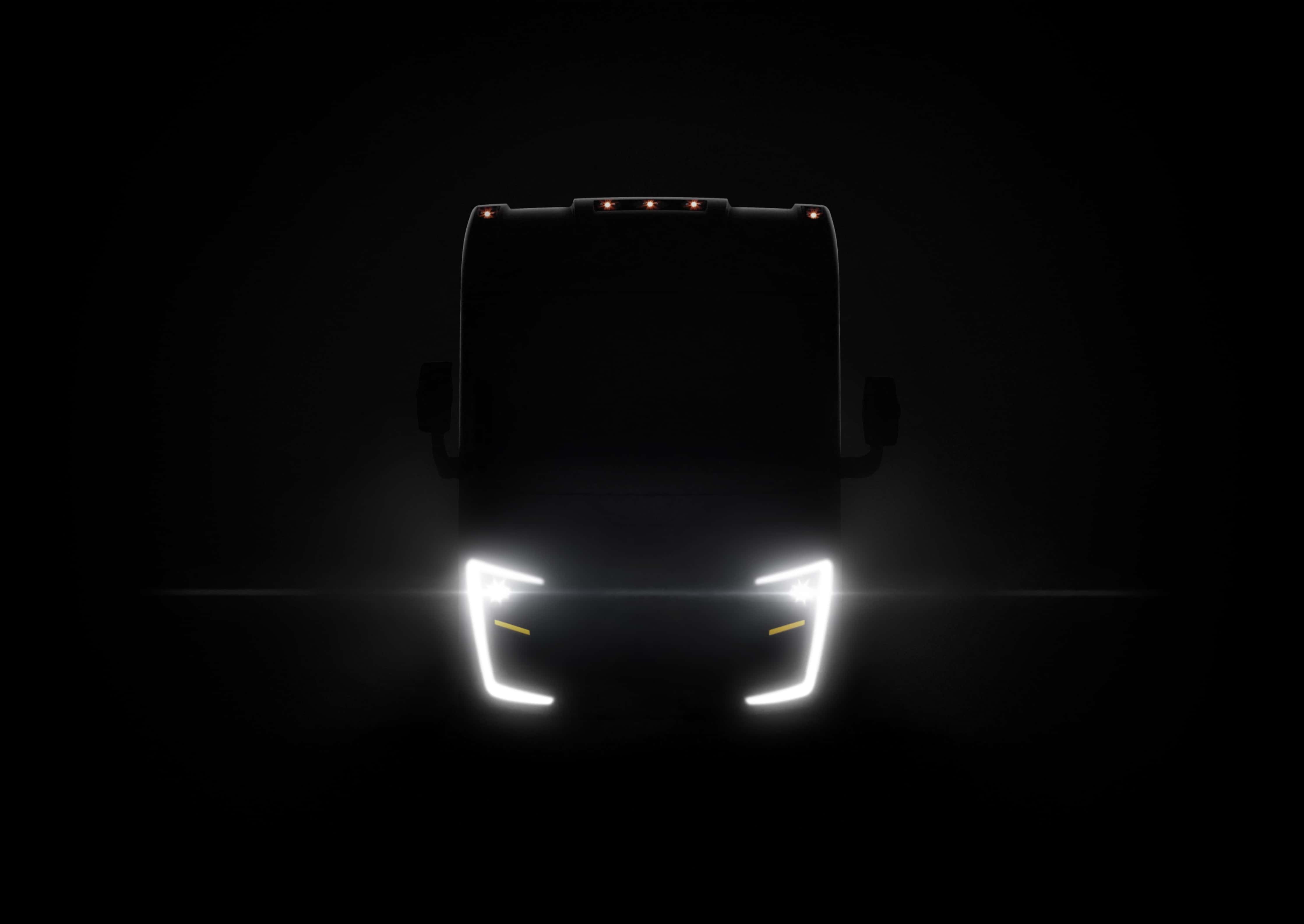 A Cornerstone coach in dark mysterious lighting with the coach running lights and headlights lit up