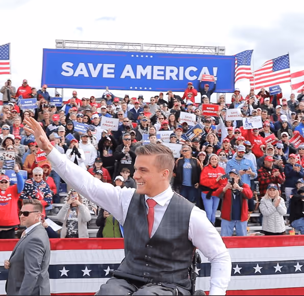 Flags crossed under a beam of light in a dimly lit stone archway.