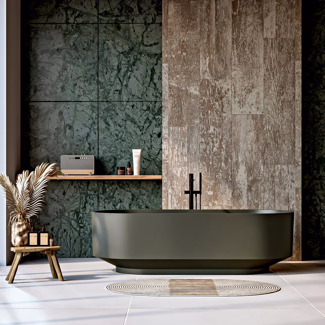 Modern bathroom with matte dark green freestanding bathtub, wooden accent wall, green marble tiled wall, wooden stool with dried plants, and circular rug on tiled floor in contemporary bathroom design.