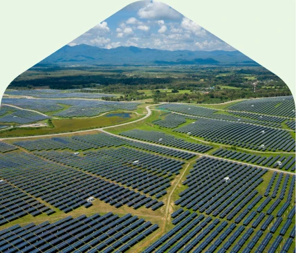 Offsite Solar Energy Projects Aerial view of a large solar farm with rows of solar panels across open land.