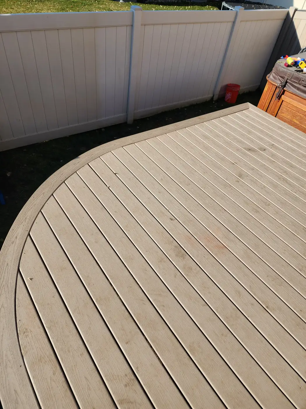 Tan composite decking with a rounded corner and a matching picture-frame border
