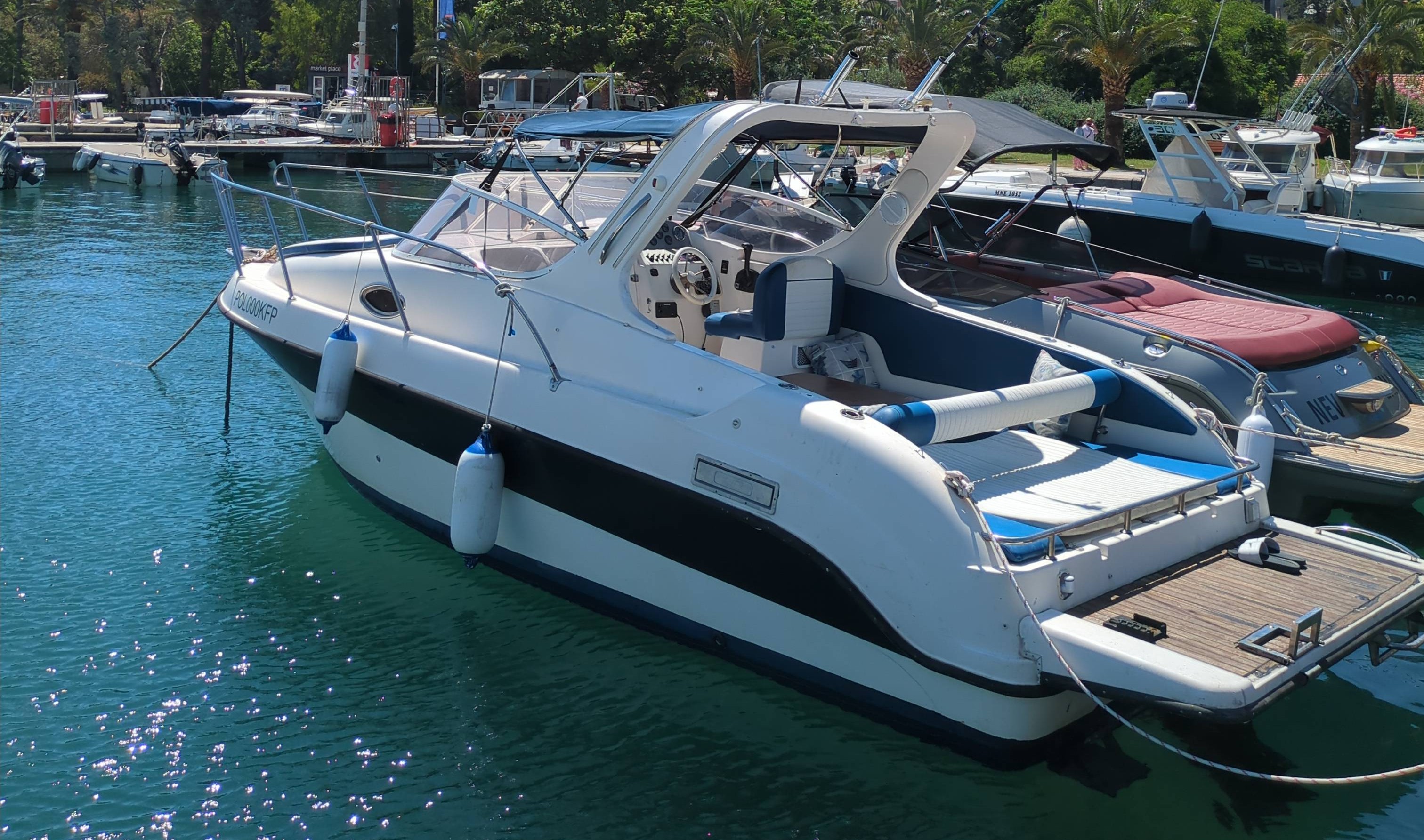 Blue icon of a sailboat with a single sail on water.