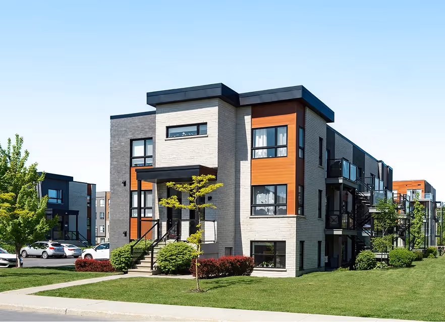 Row of modern brick townhouses with wooden accents and gardens