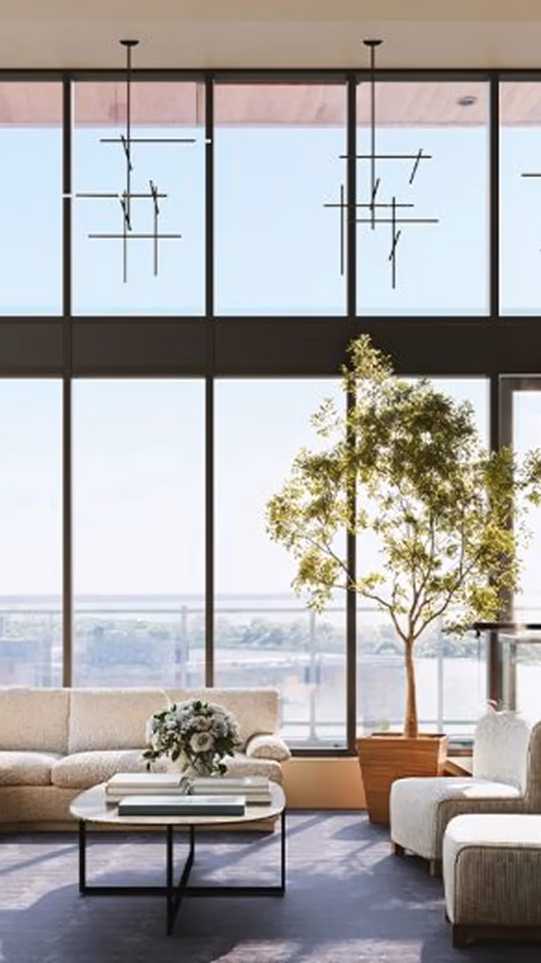 Salon avec canapé arrondi, arbre intérieur et vue panoramique sur le fleuve