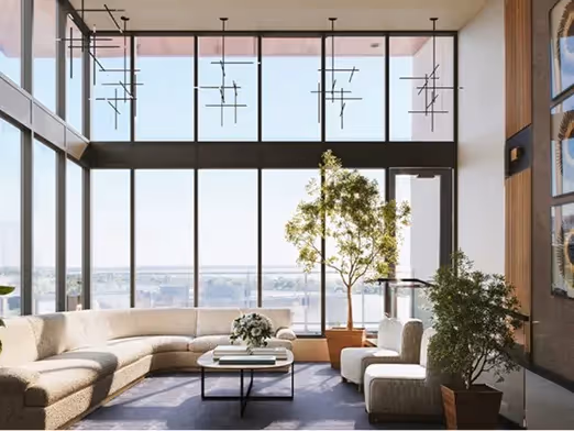 Espace lounge lumineux avec canapé arrondi, grandes baies vitrées et plantes intérieures