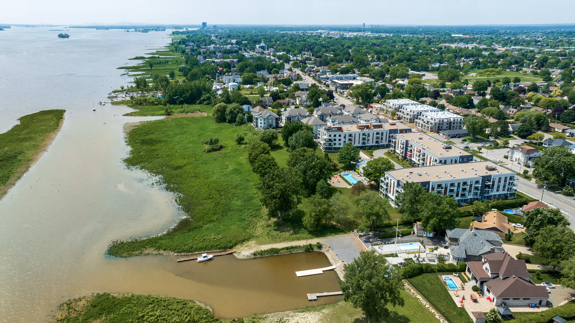Vue aérienne du Neuf Cent Notre-Dame en bord du fleuve Saint-Laurent entouré de verdure