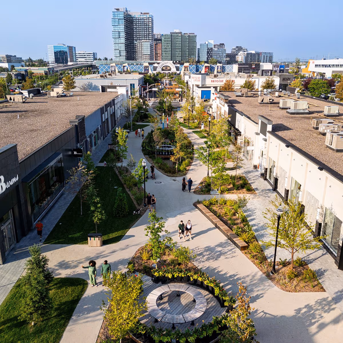 Aerial view of an open-air shopping promenade with stores and green spaces