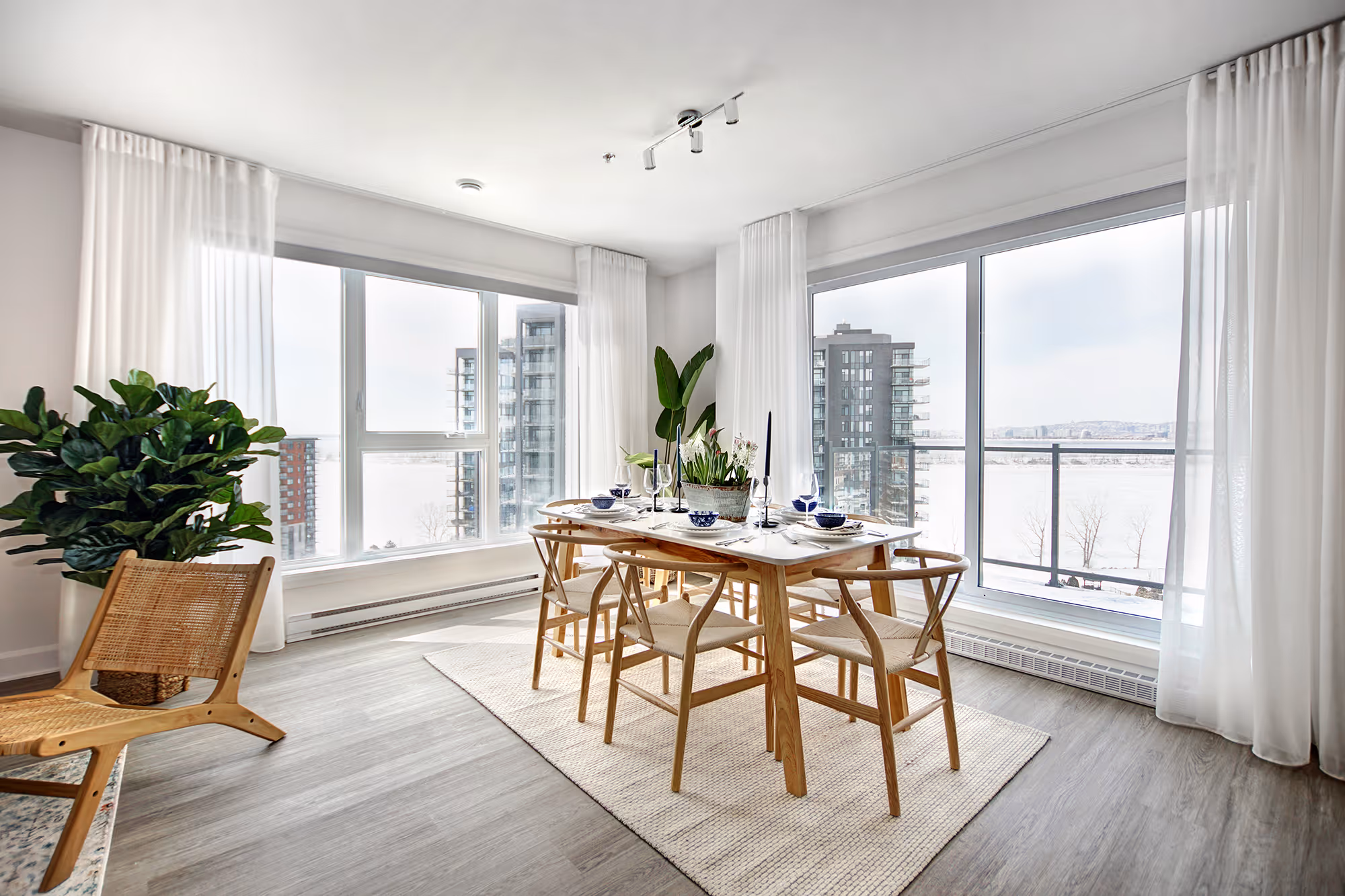 Salle à manger en bois avec chaises scandinaves et vue sur le fleuve