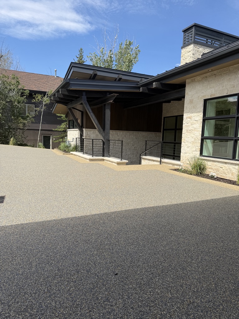 Modern garage with polished concrete floor, a black motorcycle, a black car, and organized black cabinets with tools.
