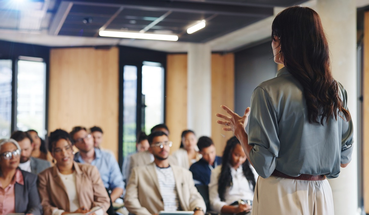 Presenter addressing a business audience in an office