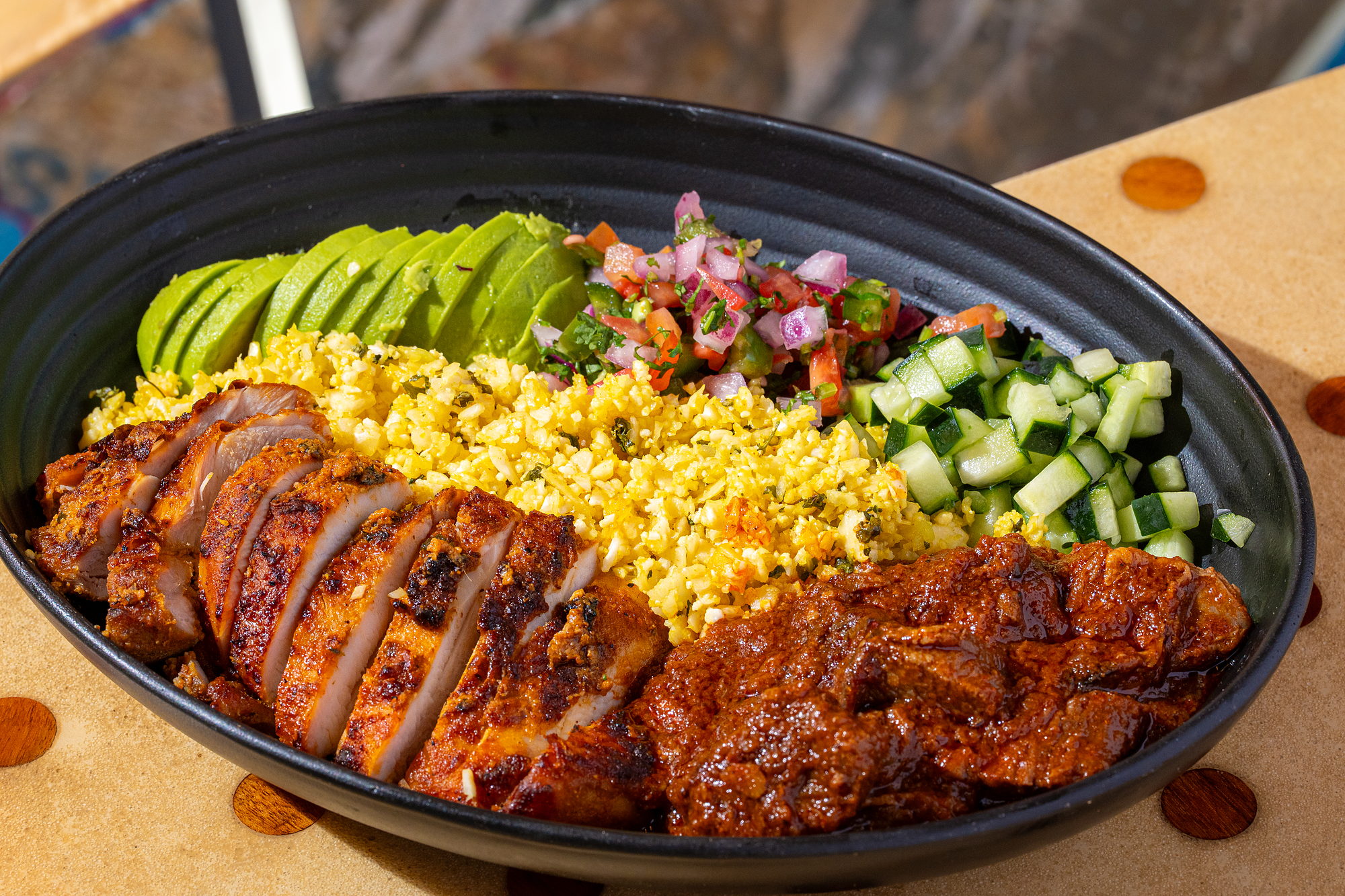 Curry Up Now Protein Bowl: tandoori chicken and lamb rogan josh with cauliflower rice, cotija, avocado, pico and cucumber