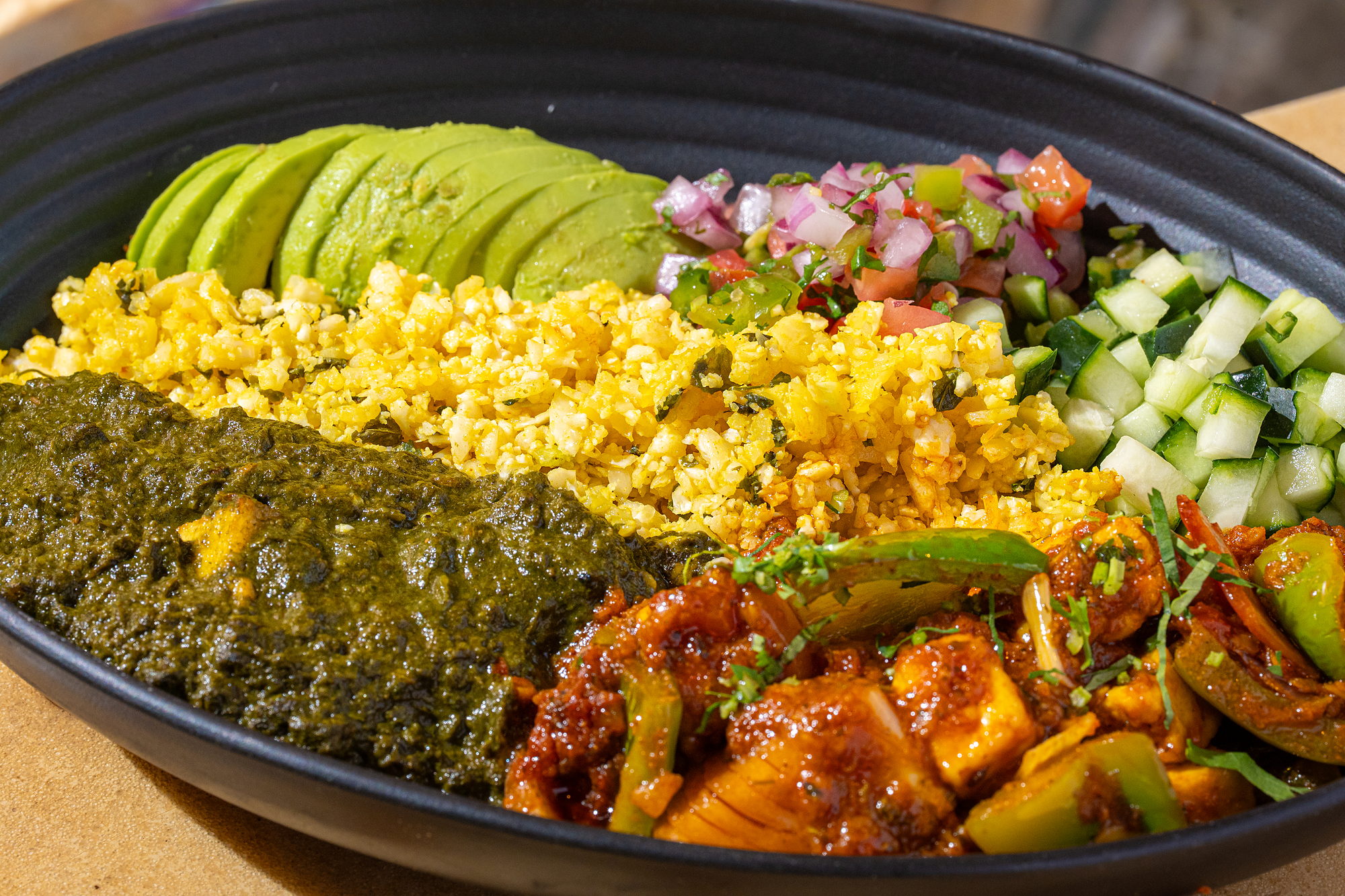 Curry Up Now Keto Bowl: kadhai chicken and saag paneer with cauliflower rice, avocado, pico and cucumber
