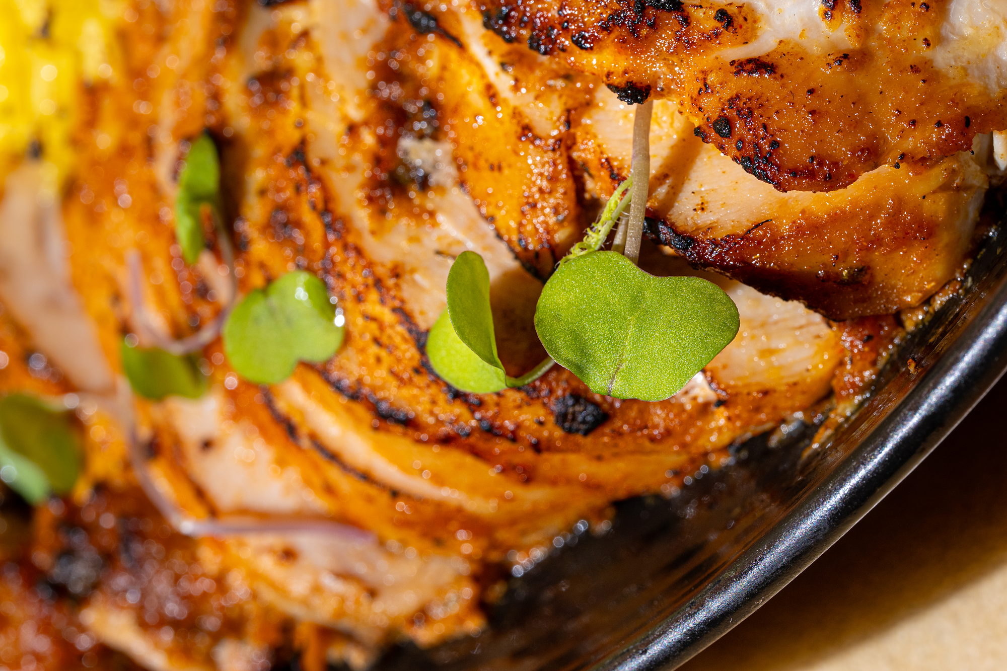 Curry Up Now 550 Bowl close-up: tandoori chicken, turmeric rice, grilled peppers and onions, lemon and cilantro chutney