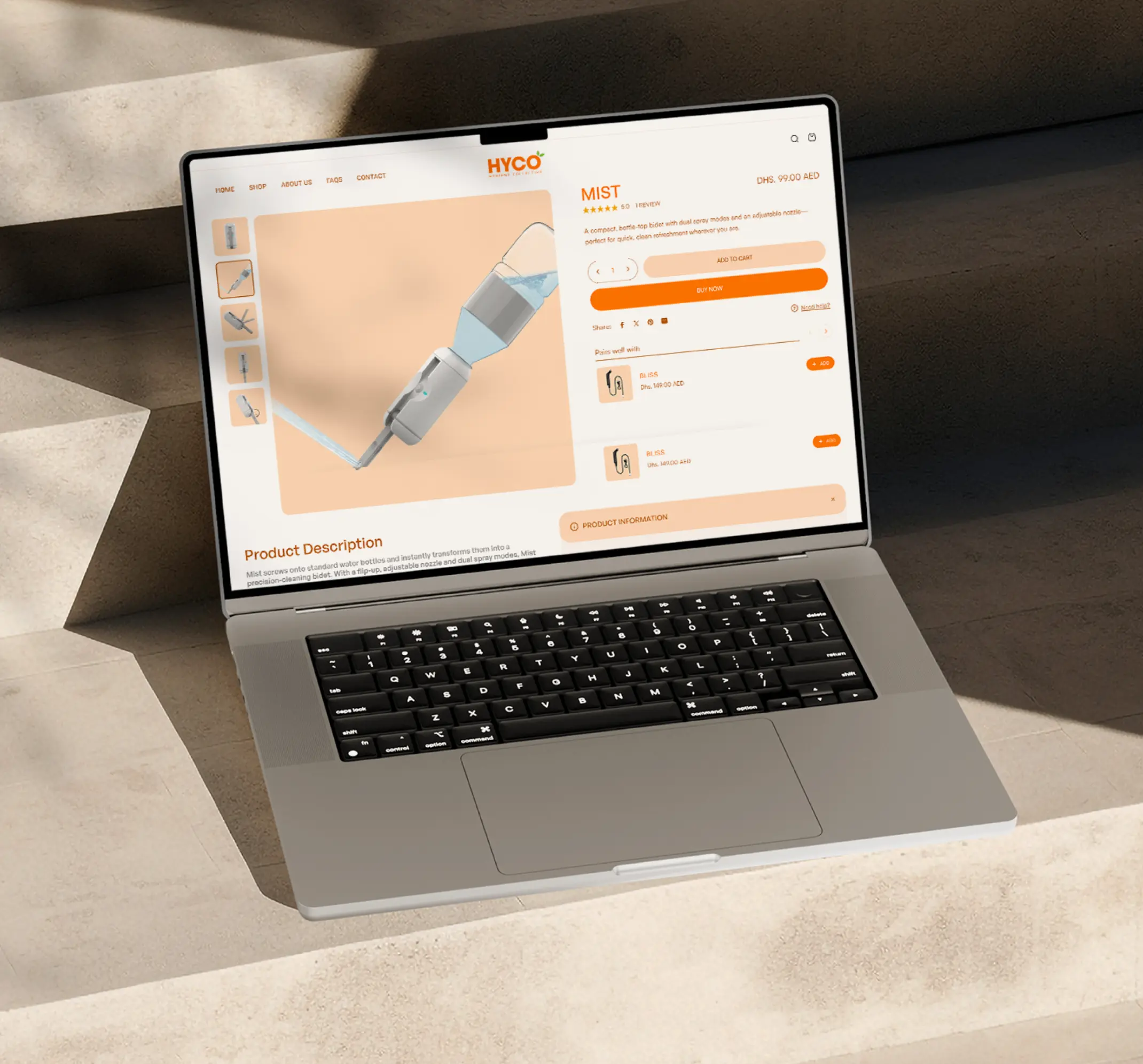 Open laptop on beige surface displaying an online product page for a compact bidet called 'MIST' with price and description.