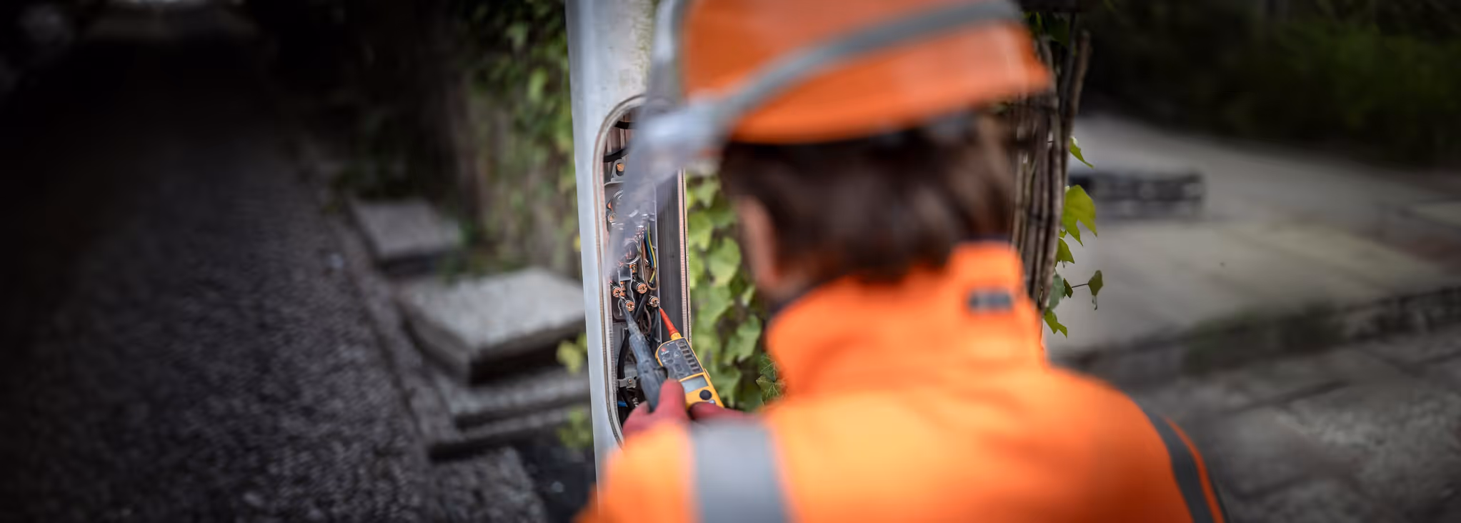 Monteur in oranje werkkleding aan het werk op straat