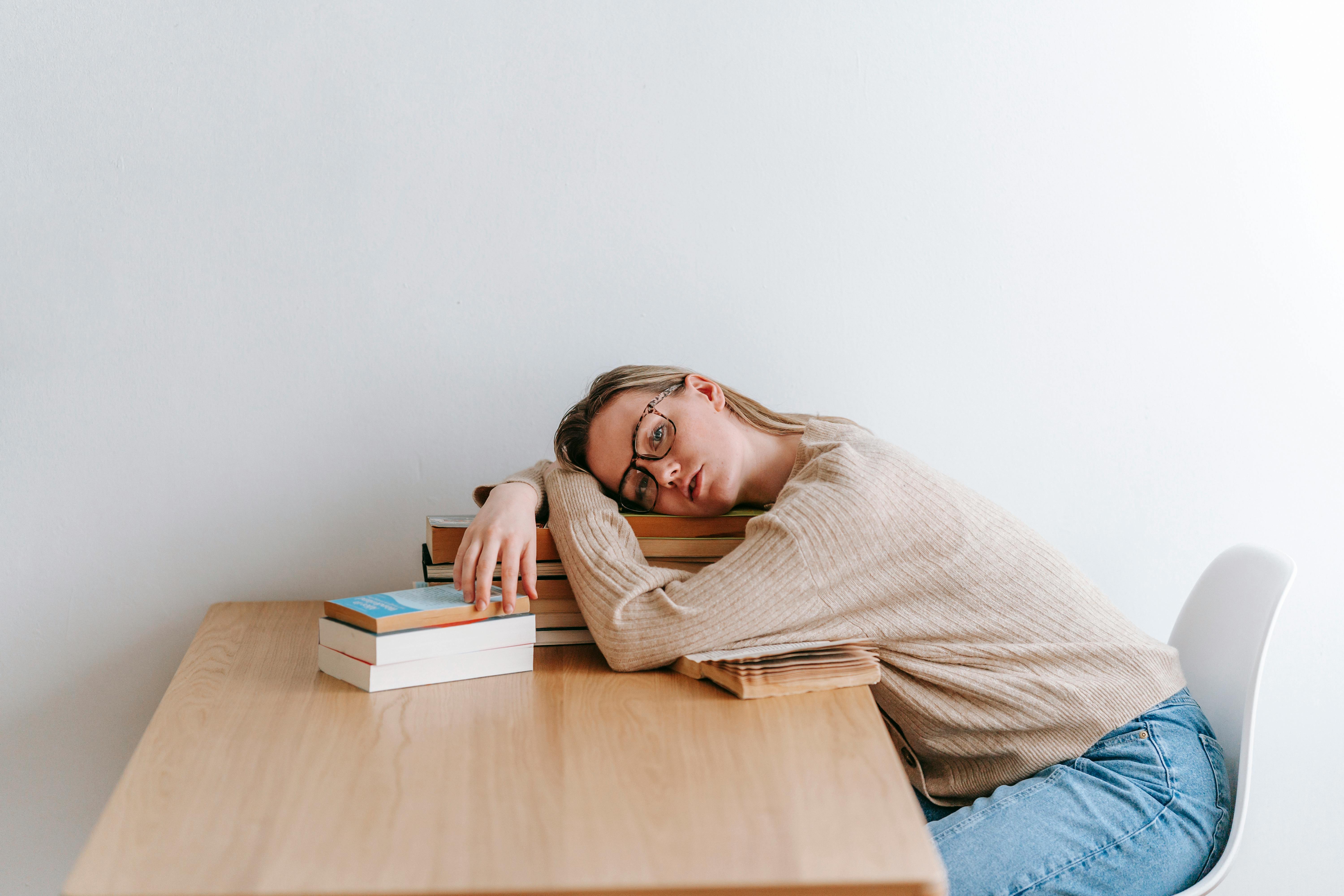 woman laying on top of books sleeping