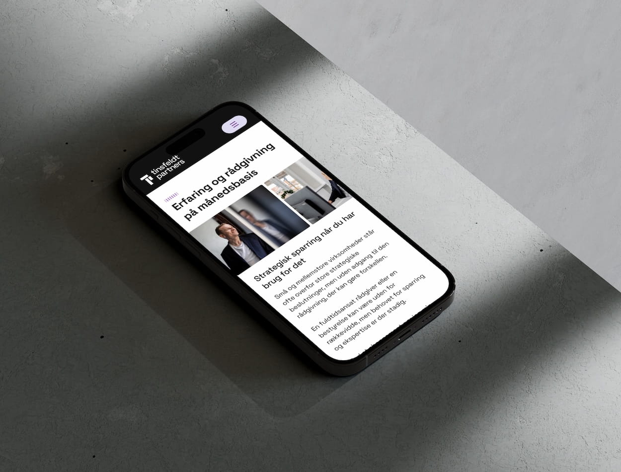 Smartphone der viser en webside på dansk med titlen 'Erfaring og rådgivning på månedsbasis' med billeder af mennesker der arbejder og tekst om strategiske besparelser og rådgivning.