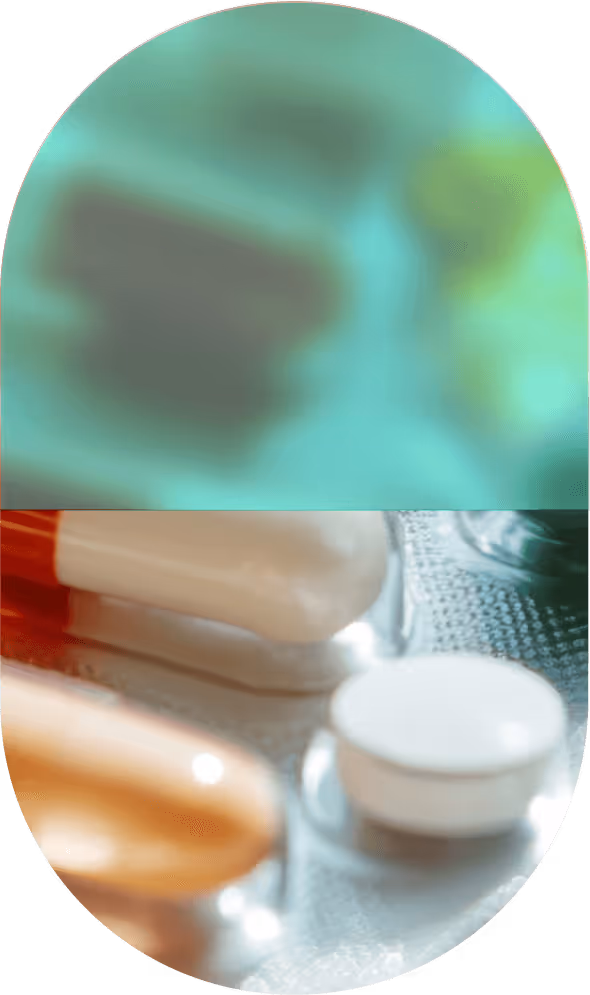 Close-up view of various pills on a blister pack, including capsules and a round tablet.