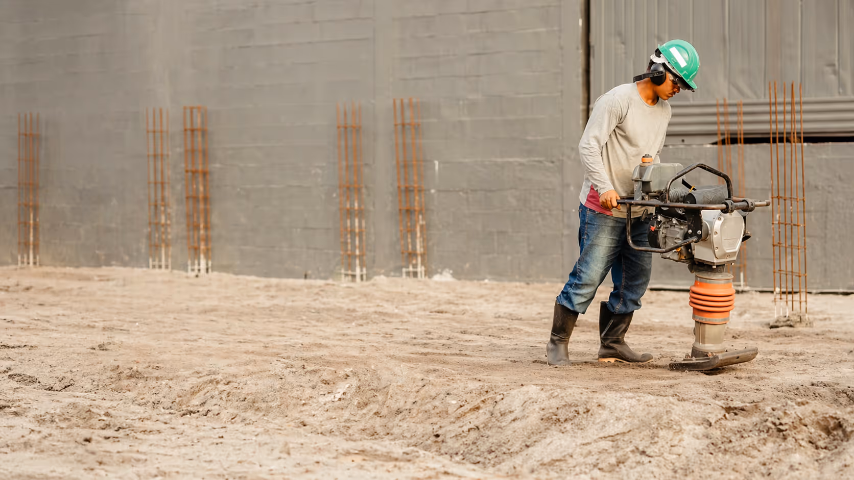 Construction worker on a building site wearing safety gear.