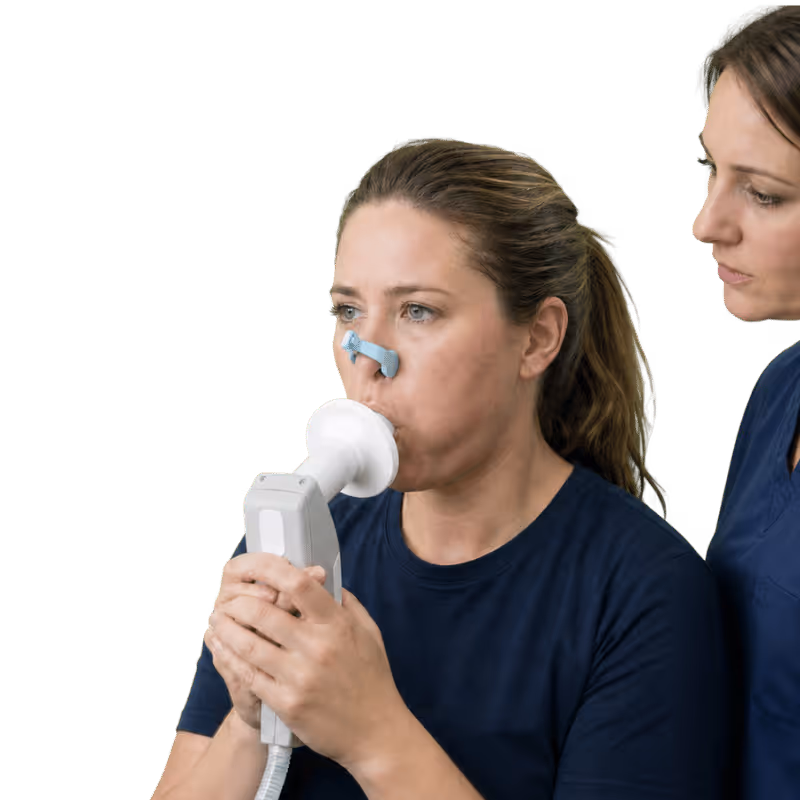 Woman undergoing spirometry lung function test with mouthpiece and nose clip, observed by a healthcare professional.