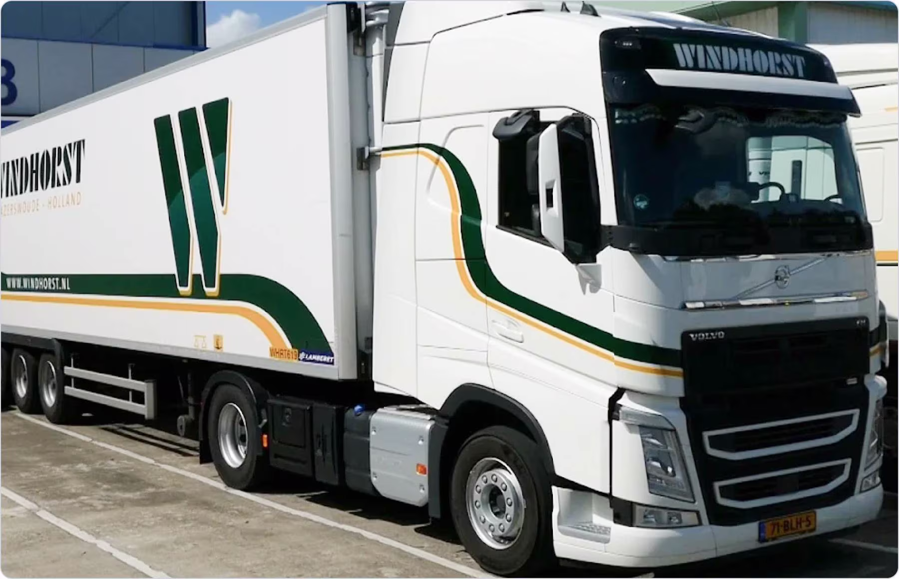 Two men standing and reviewing a tablet together in a softly lit office.