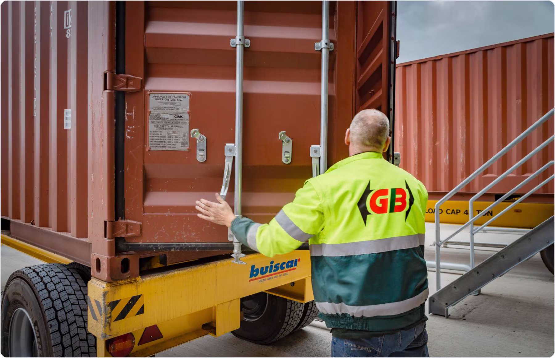 Two men standing and reviewing a tablet together in a softly lit office.