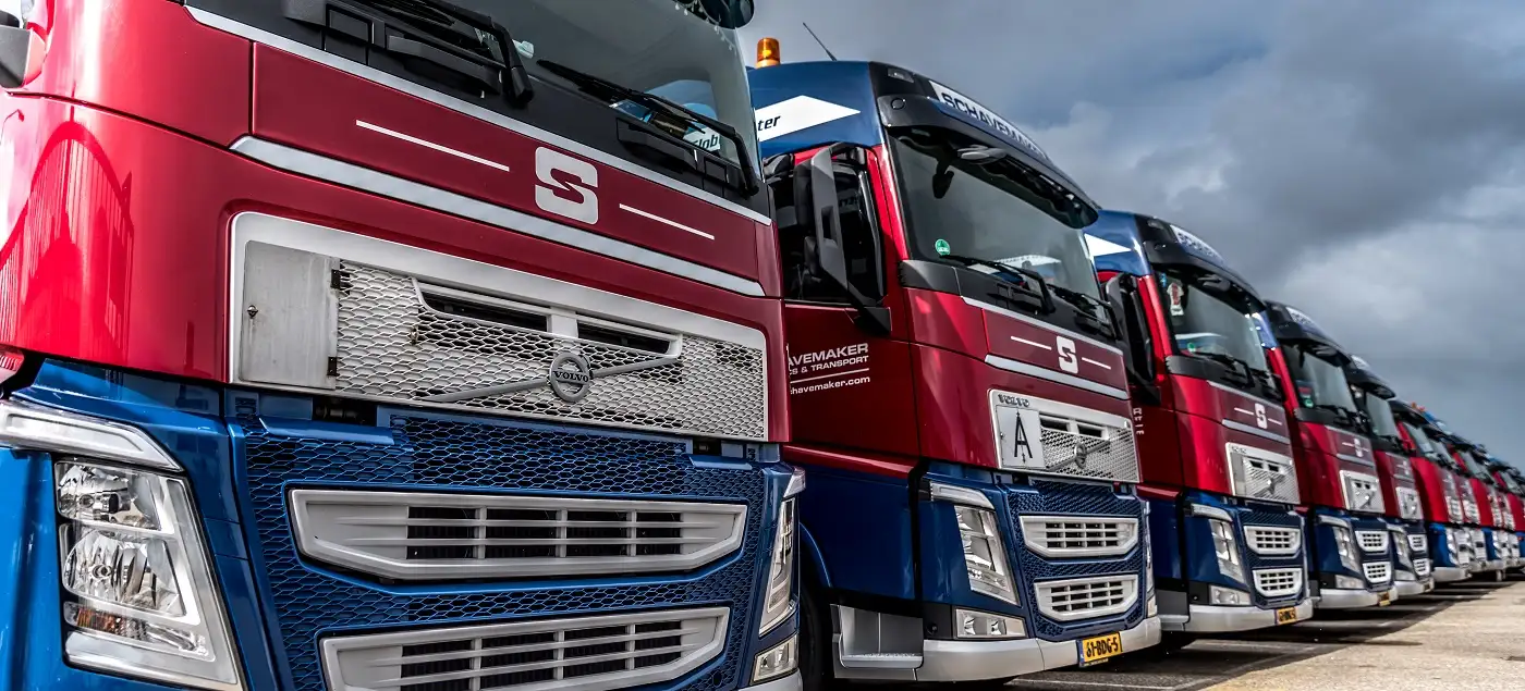 Two men standing and reviewing a tablet together in a softly lit office.