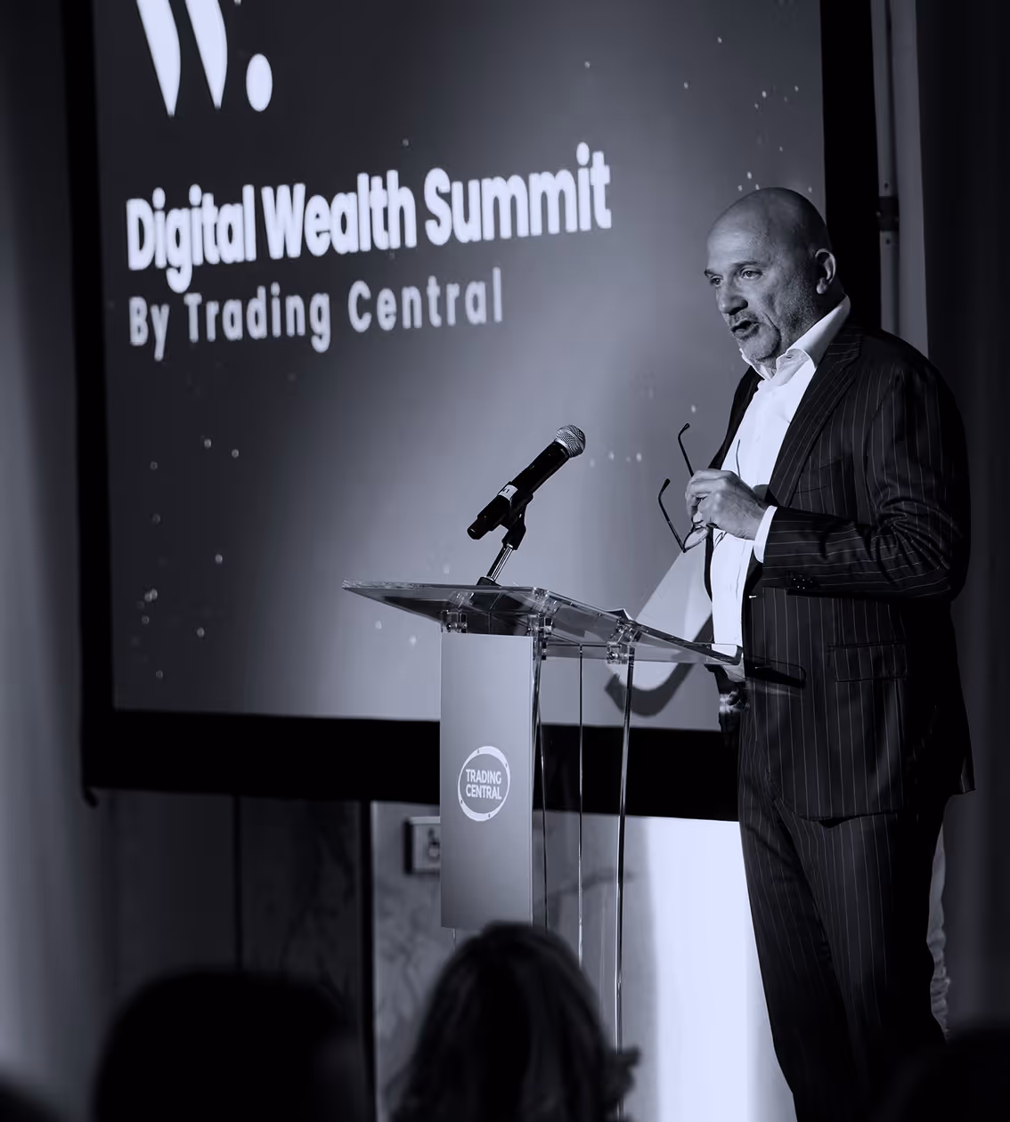 TC CEO speaking at a podium with a microphone at the Digital Wealth Summit by Trading Central.