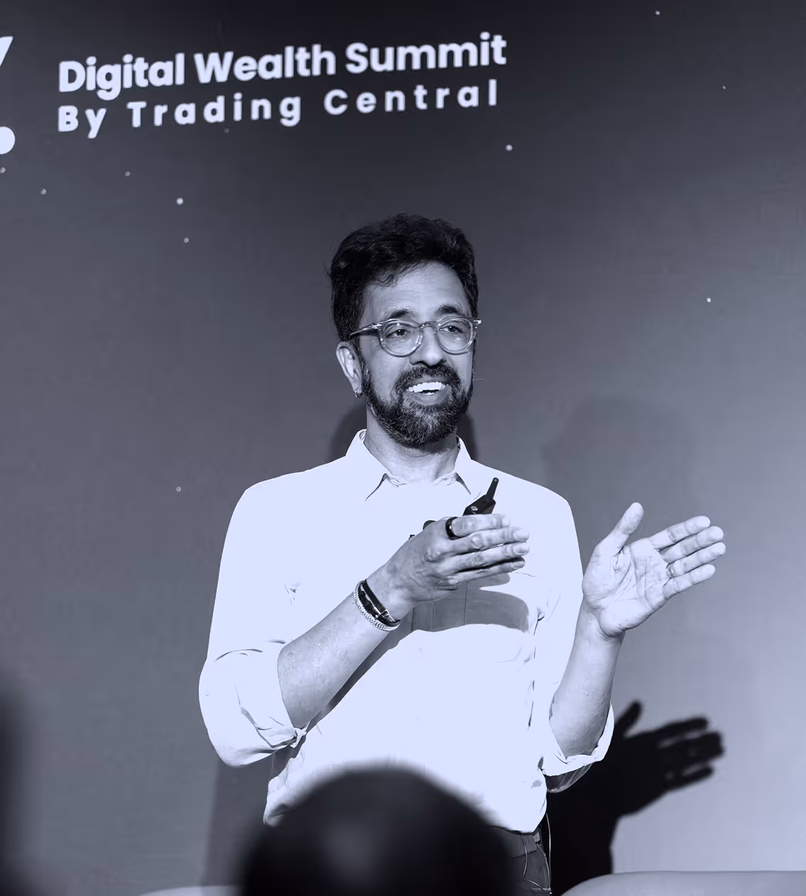 Panelist with glasses speaking and gesturing during Digital Wealth Summit by Trading Central.