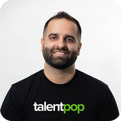 Smiling man with short dark hair and beard wearing a black TalentPop t-shirt against a plain white background.