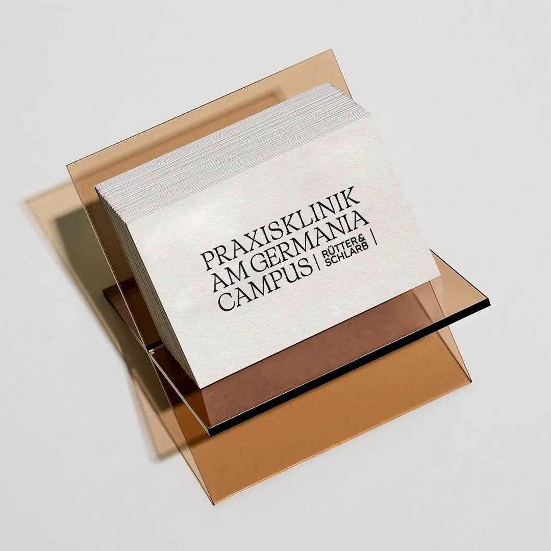 Ein Visitenkartenständer mit den Visitenkarten der Praxisklinik am Germania Campus | Dr. Rütter und Dr. Schlarb