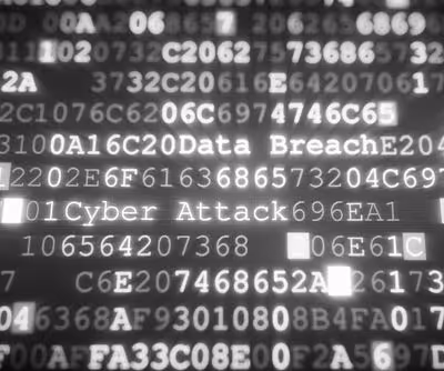Glowing white text on dark background showing phrases Data Breach and Cyber Attack among numbers.