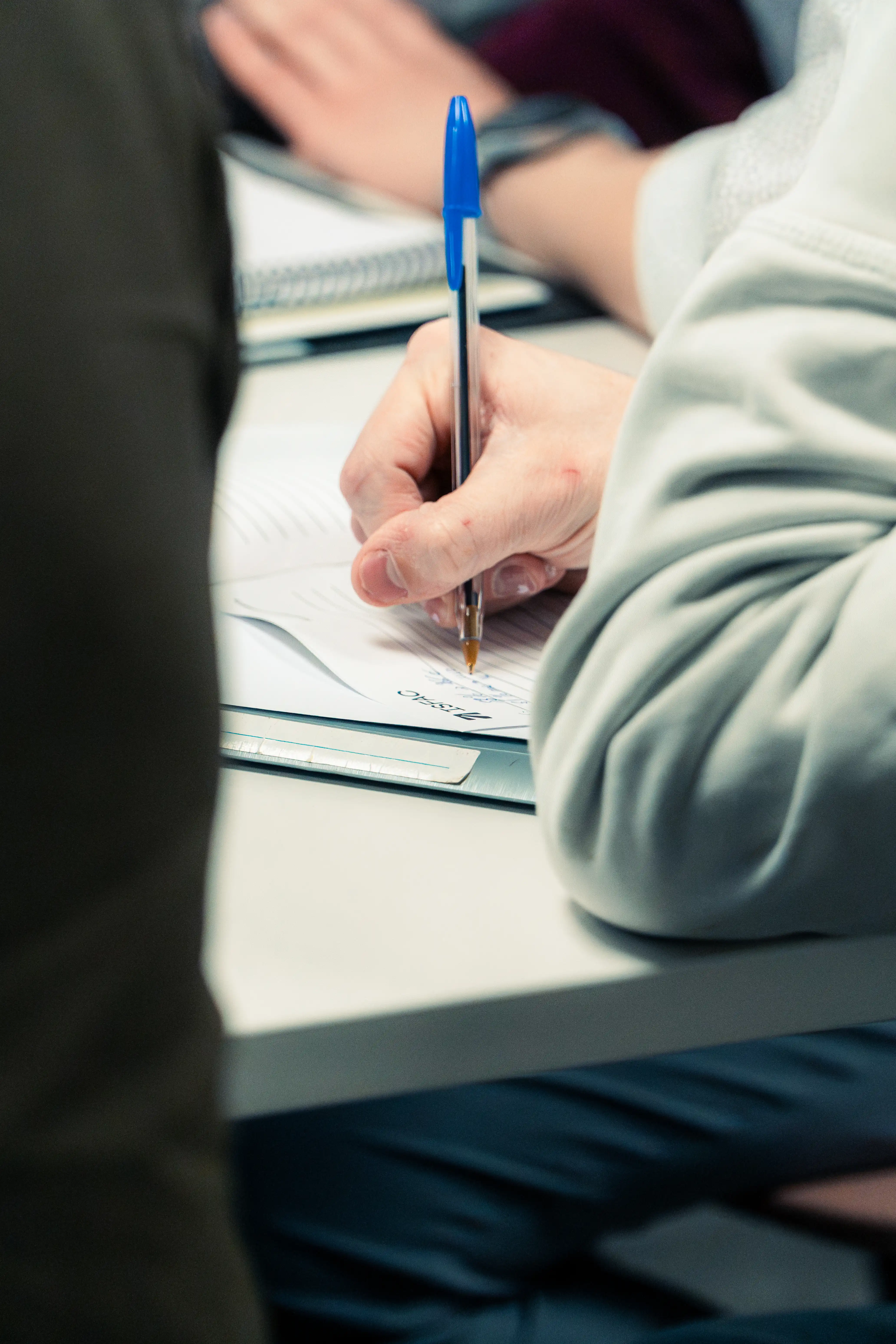 Apprenant prenant des notes pendant un travail de groupe ISFAC