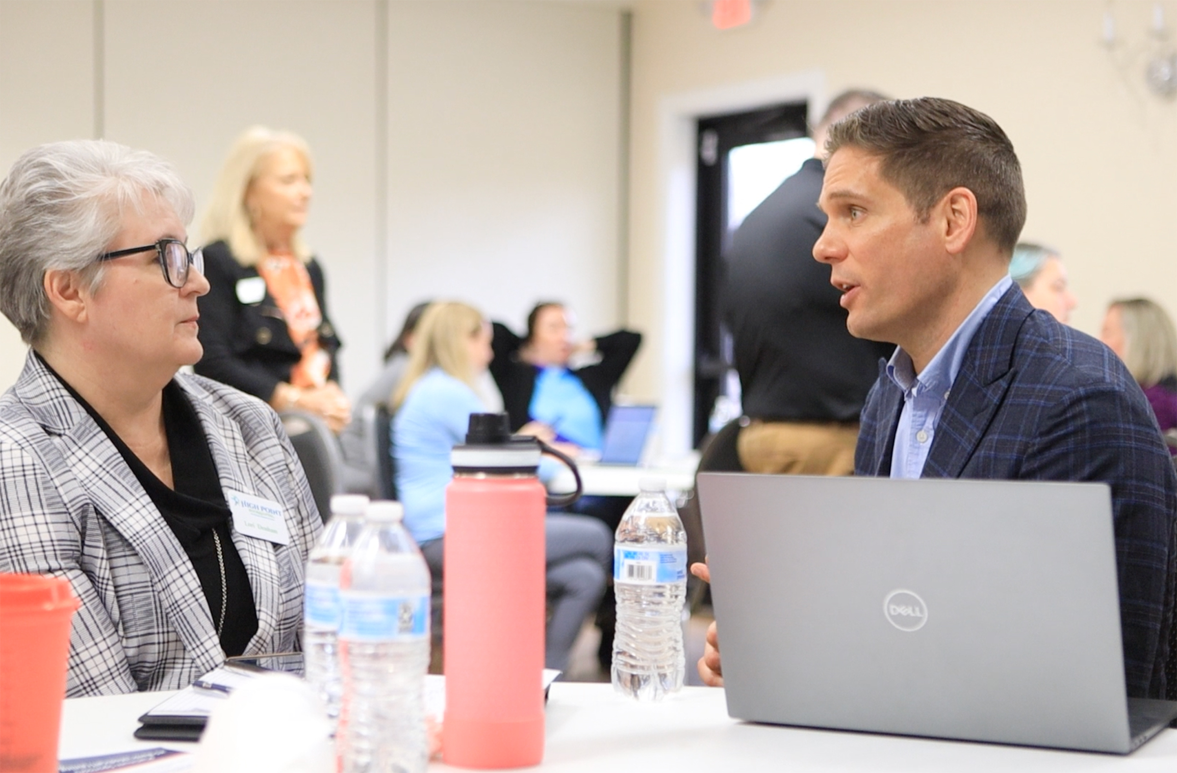 Zach Giglio leading a hands-on AI training workshop with participants at laptops