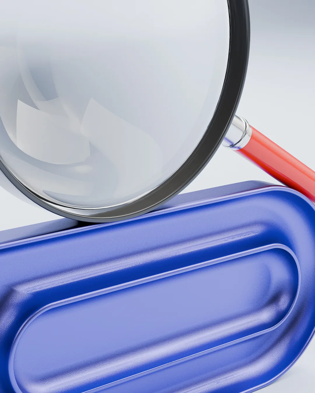 Close-up of a magnifying glass with a red handle resting on a blue object with rounded edges and grooves.