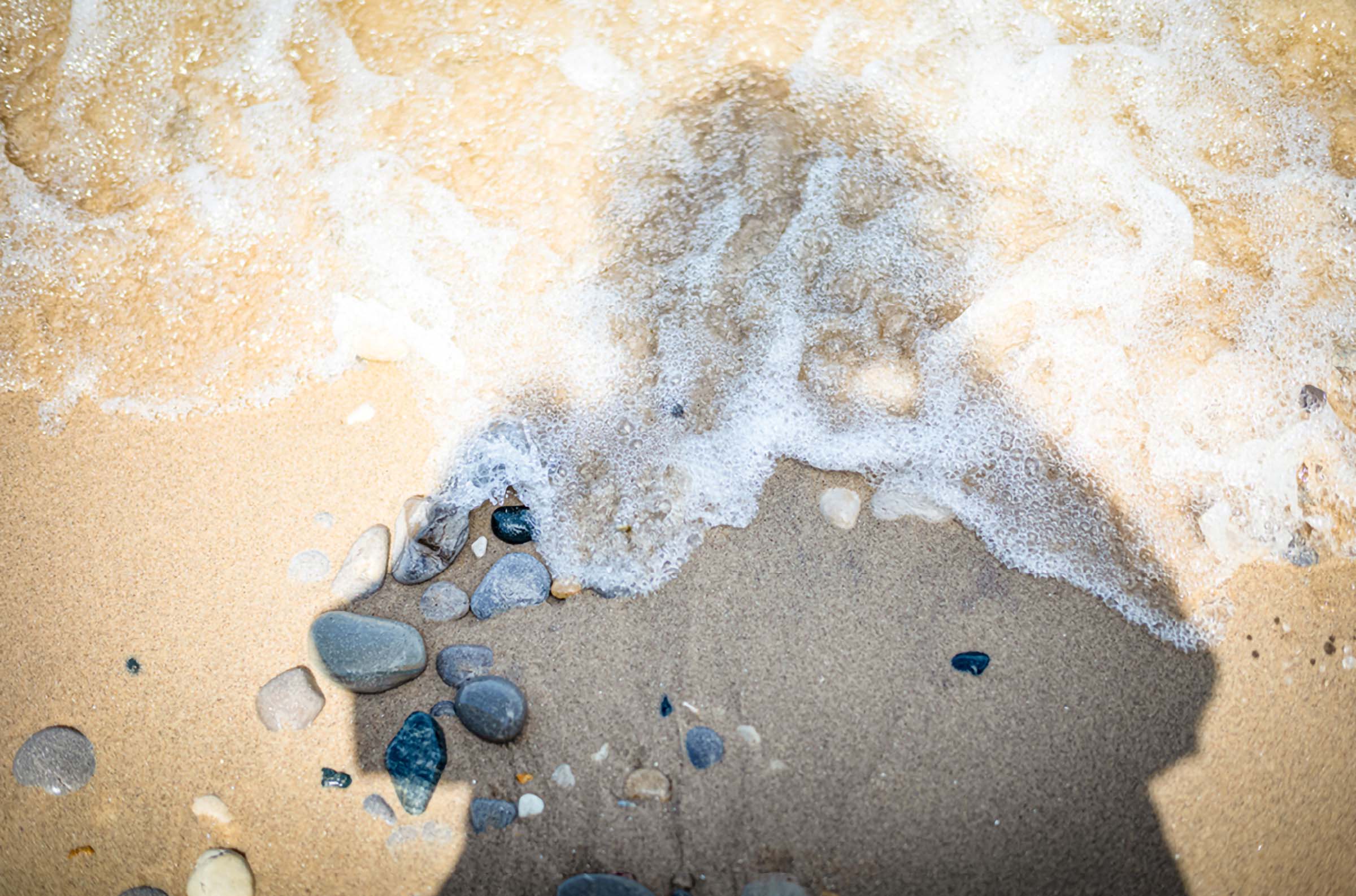 Jennifer Yaple student interpretation: frothy tide washing over dark sand and stones at Tusen Takk