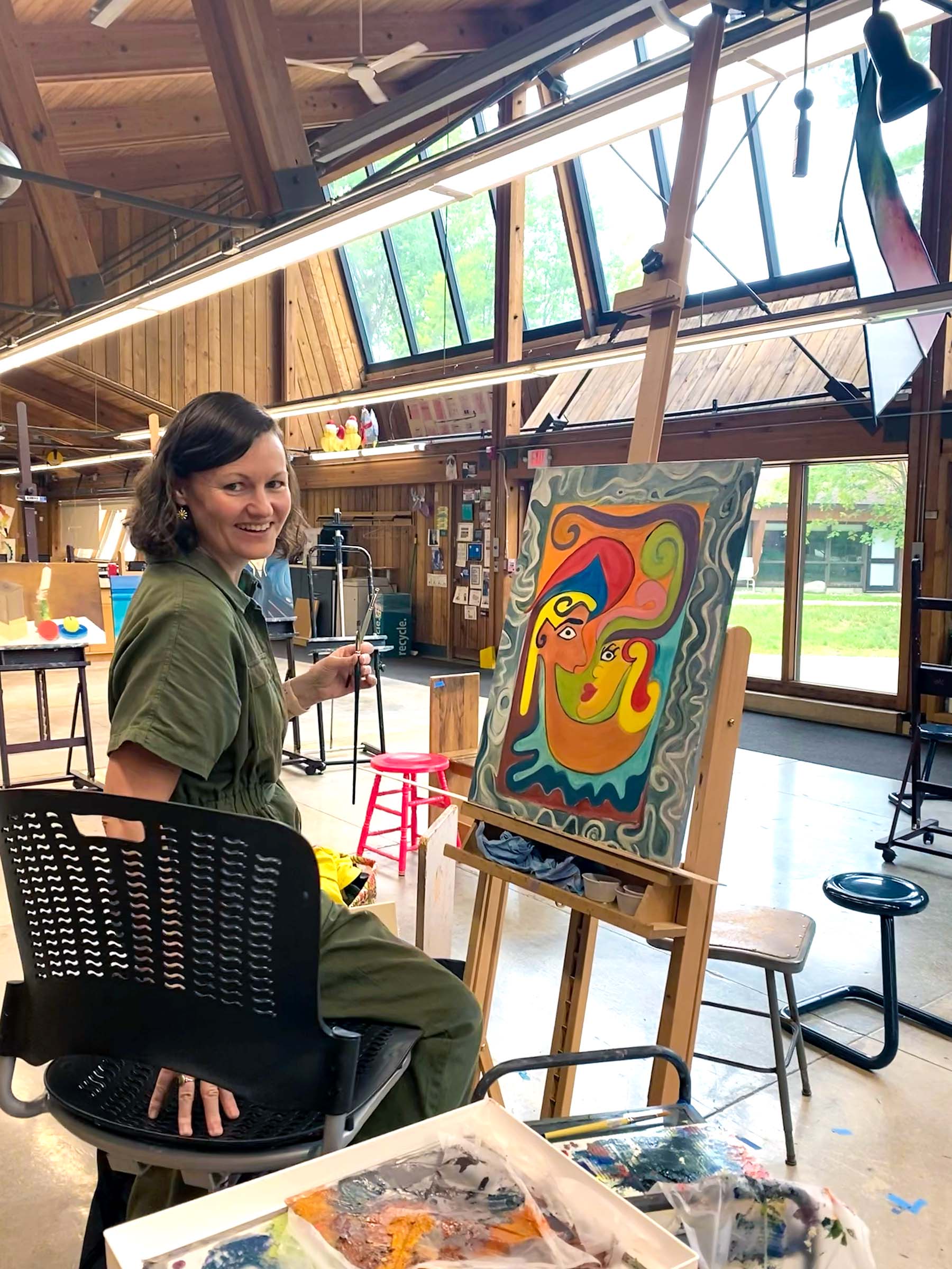 Jennifer Yaple painting the larger Blowing Smoke oil painting in the studio.