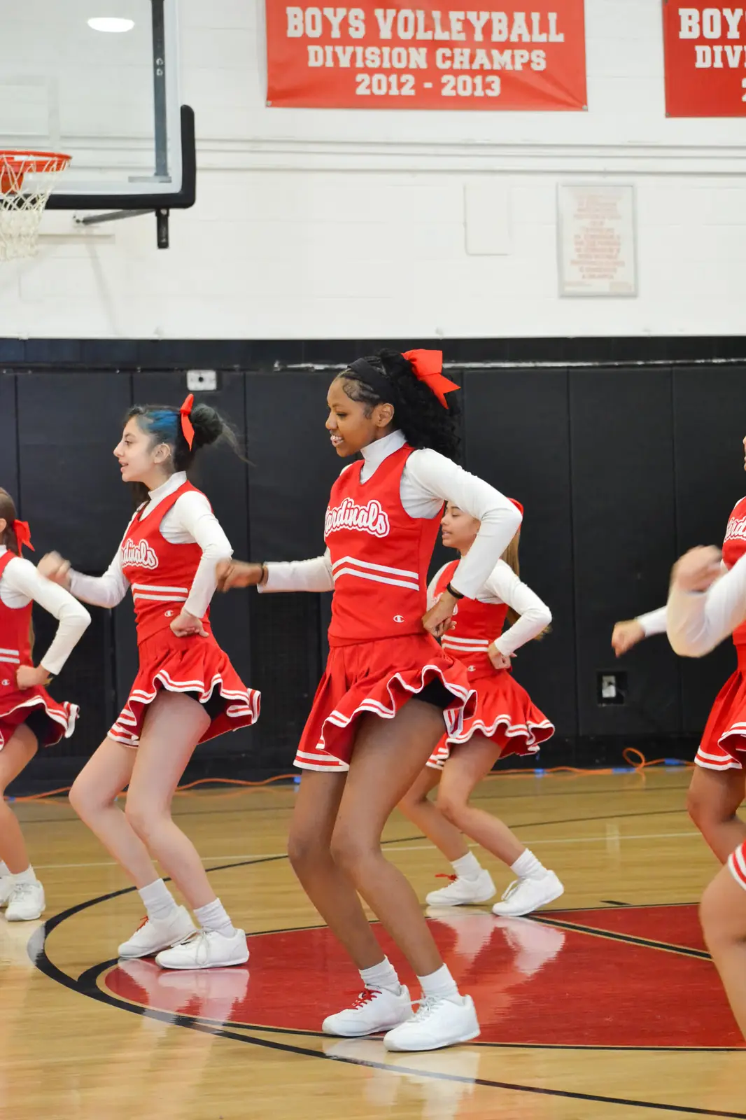 Cardinals cheerleaders performing a routine on gym floor