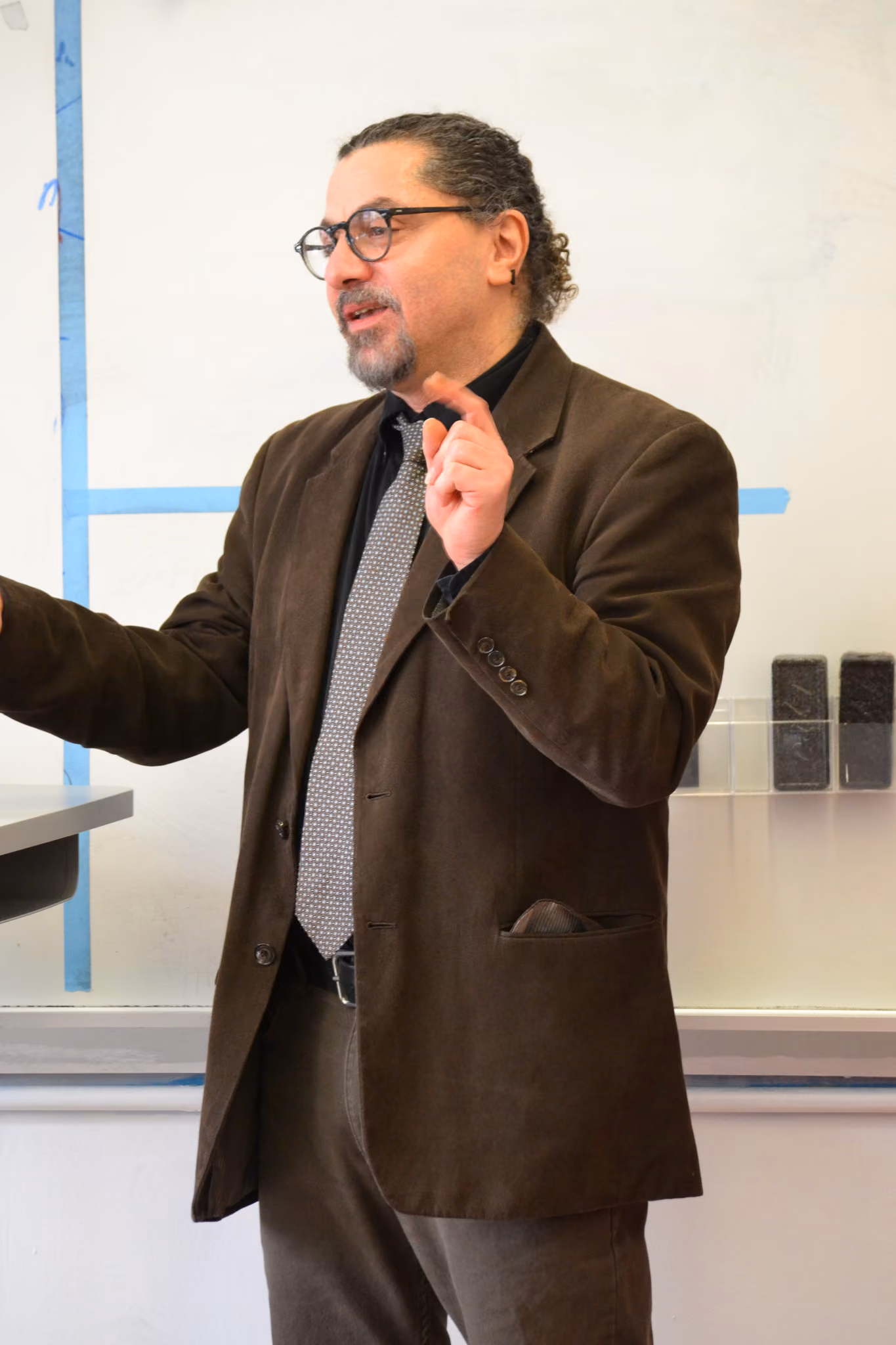 Male teacher in suit and tie presenting to classroom