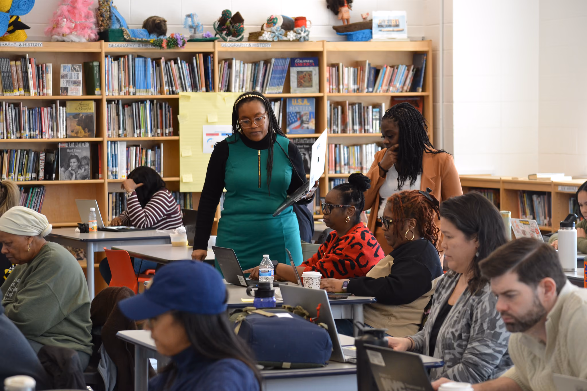 Teachers collaborating on laptops during a professional development session