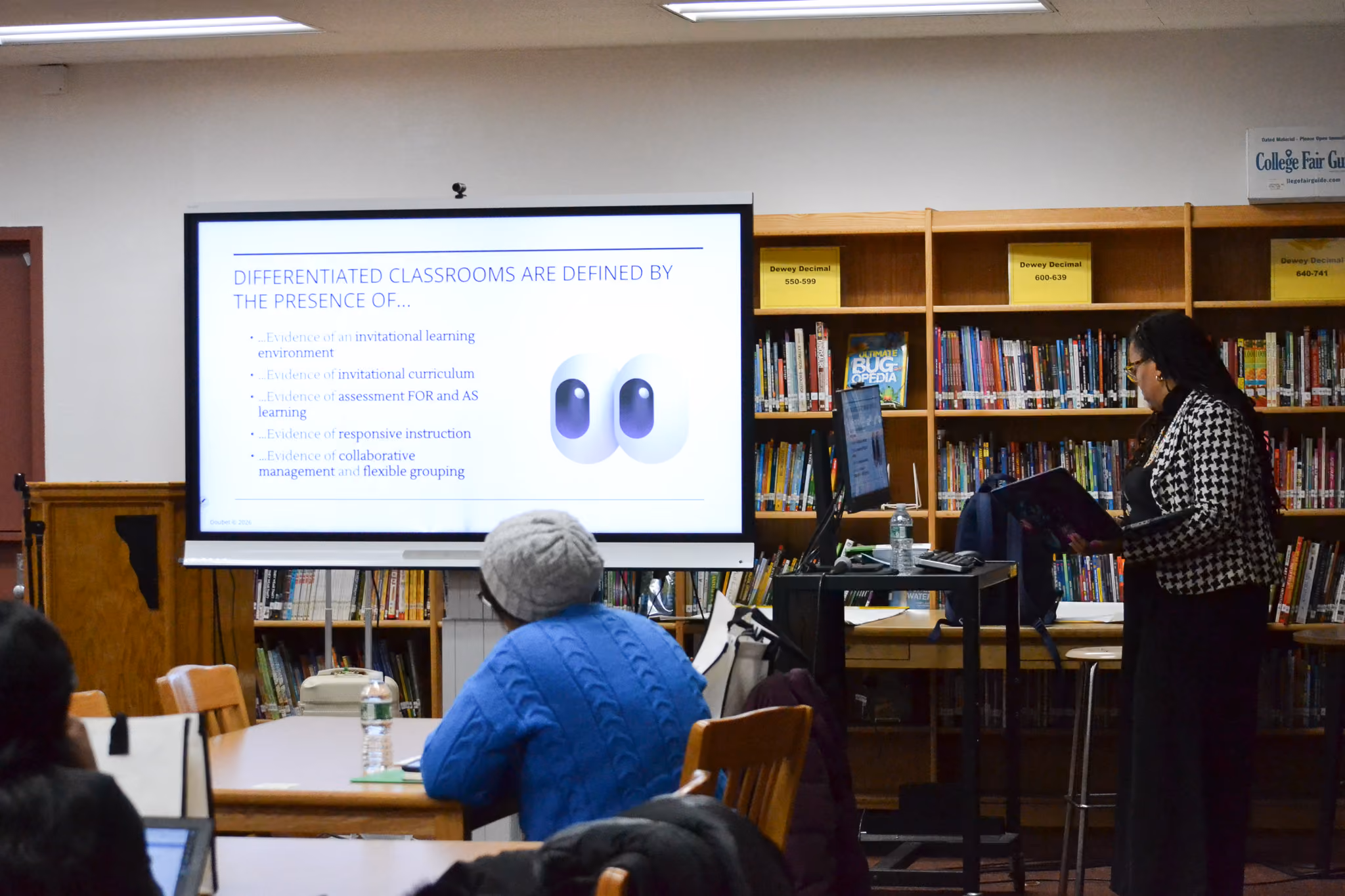 Teacher presenting differentiated classroom strategies to staff in school library