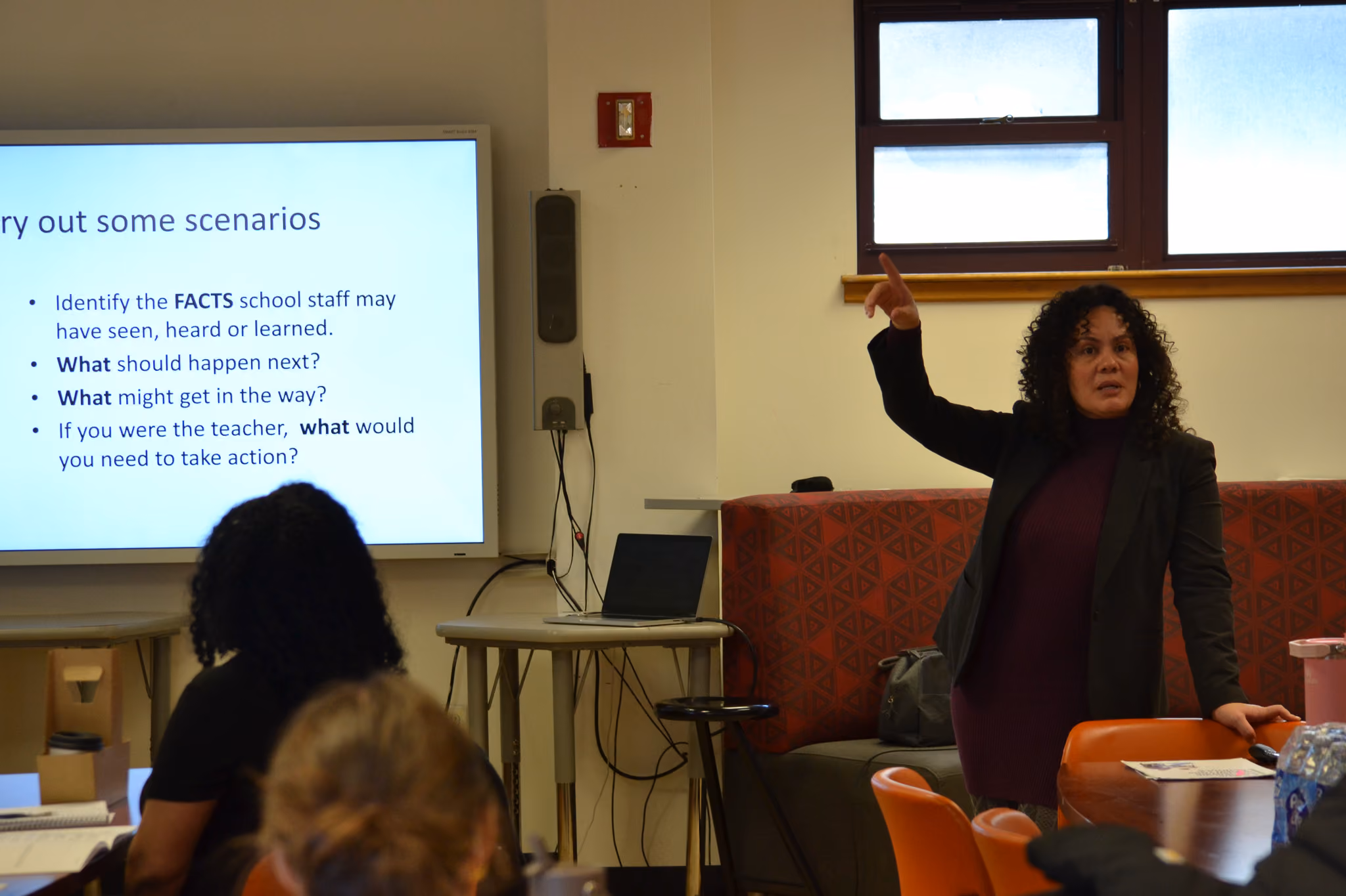 Teacher presenting scenarios slide to staff during professional development session