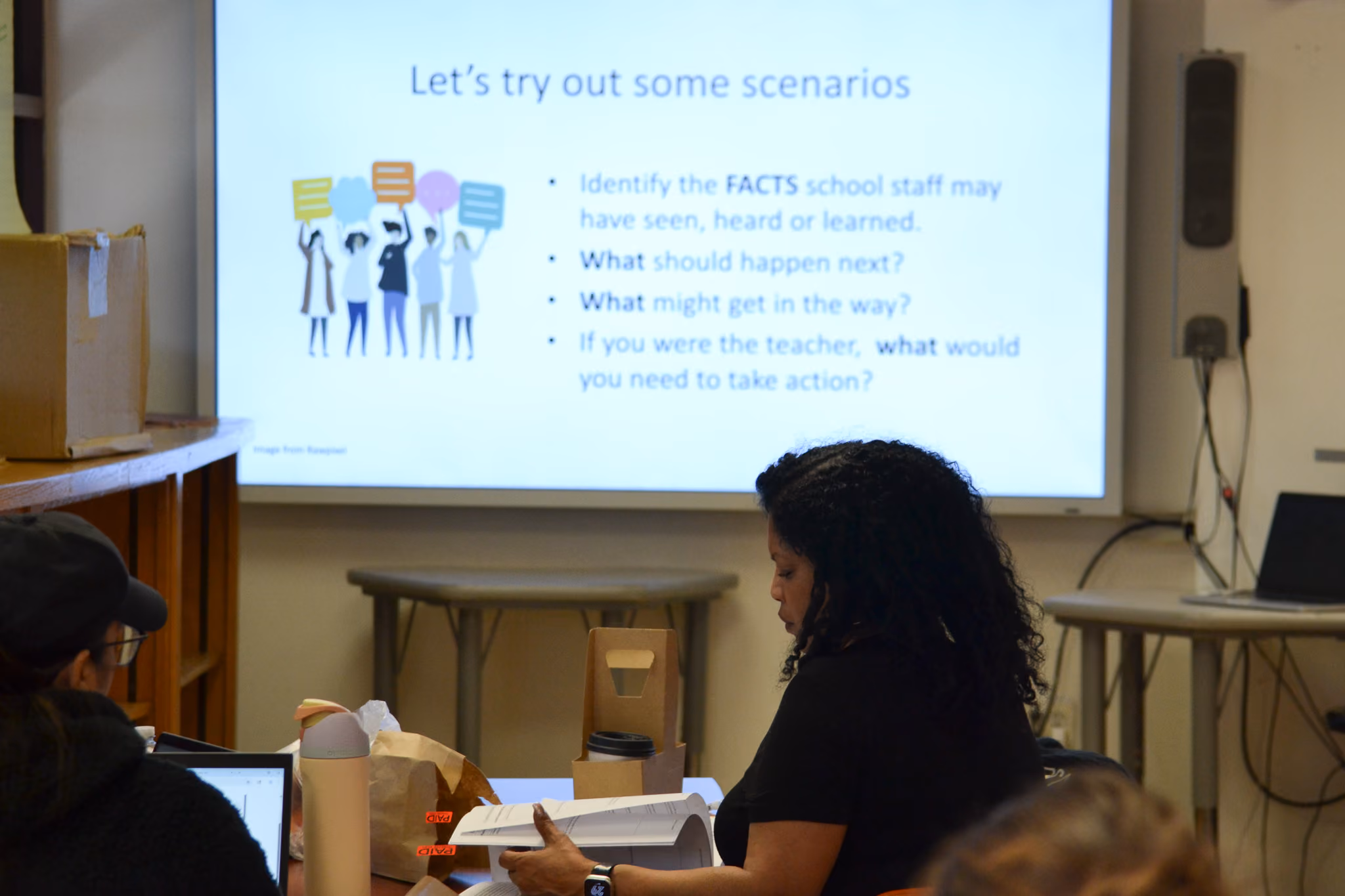 Staff members review materials during a professional development scenario training session