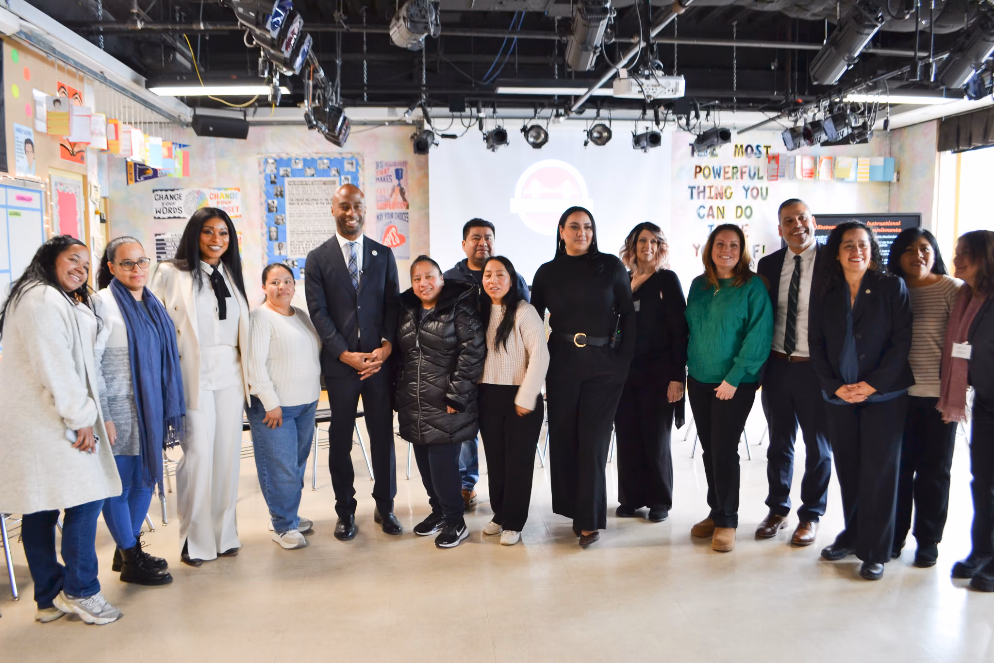 Group of staff and community members posing together in school classroom