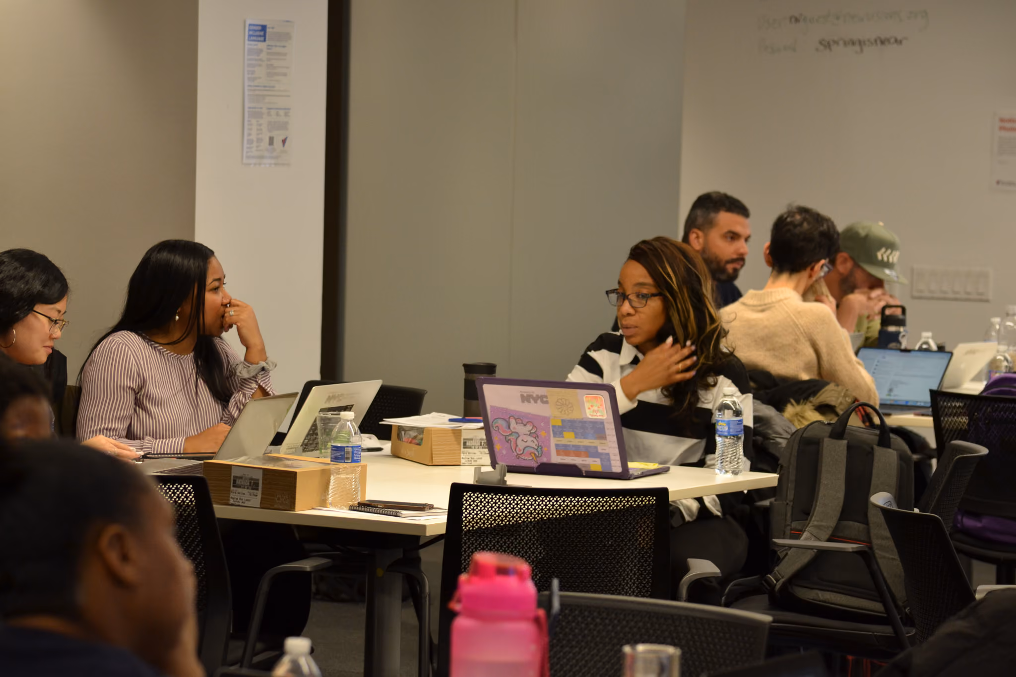 Students working on laptops during a classroom group session
