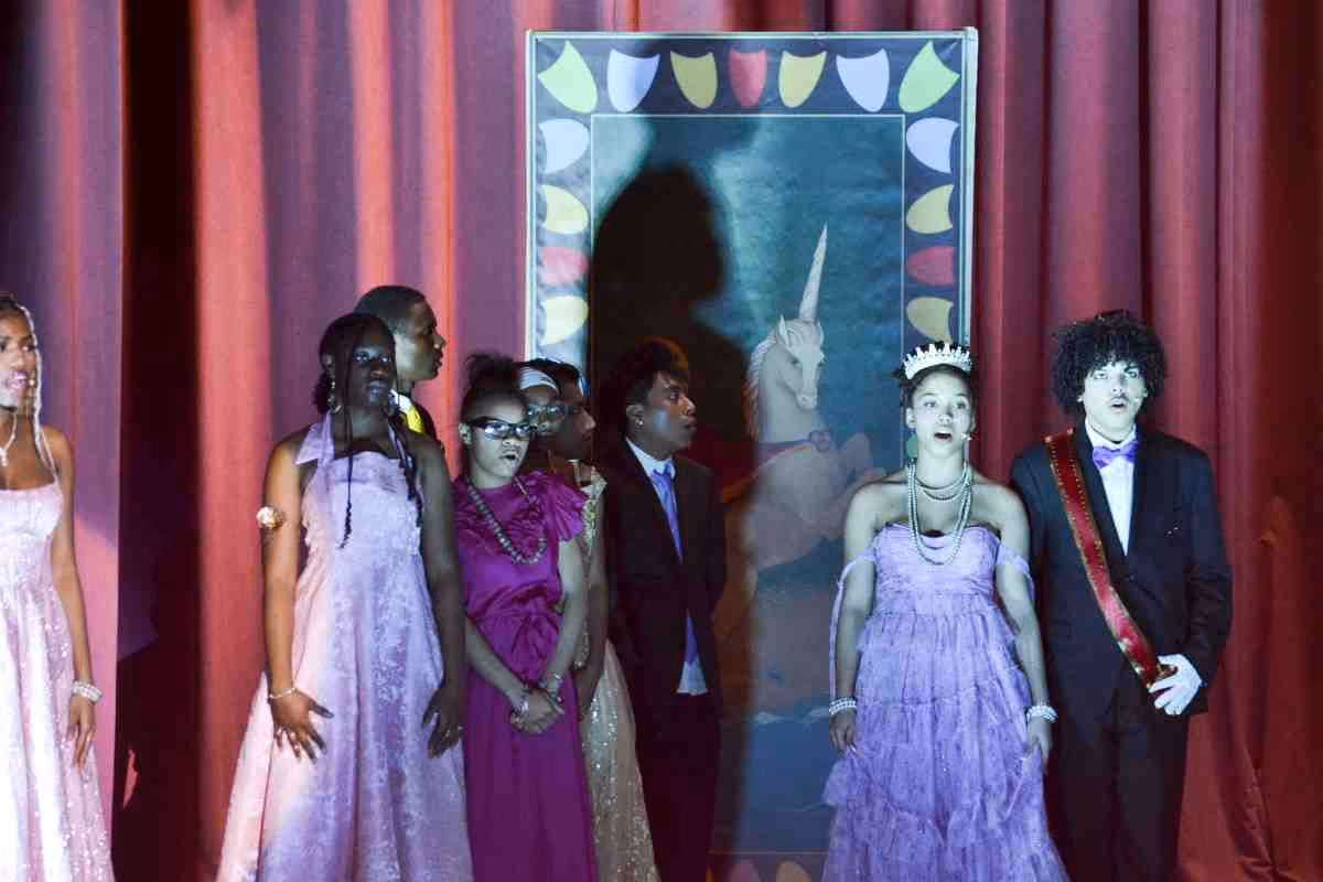 Students in formal costumes perform Cinderella on stage