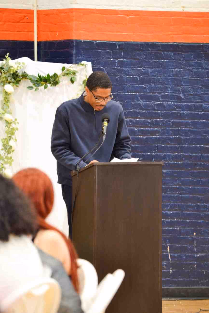 Man speaking at podium with microphone during school event
