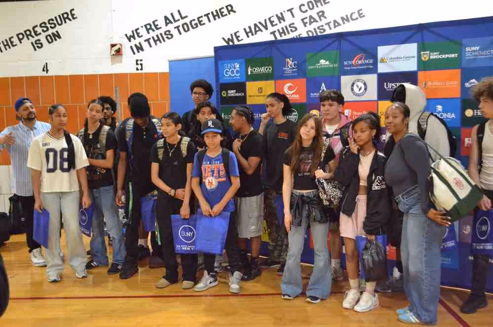 Students posing in front of SUNY college logos at a college fair