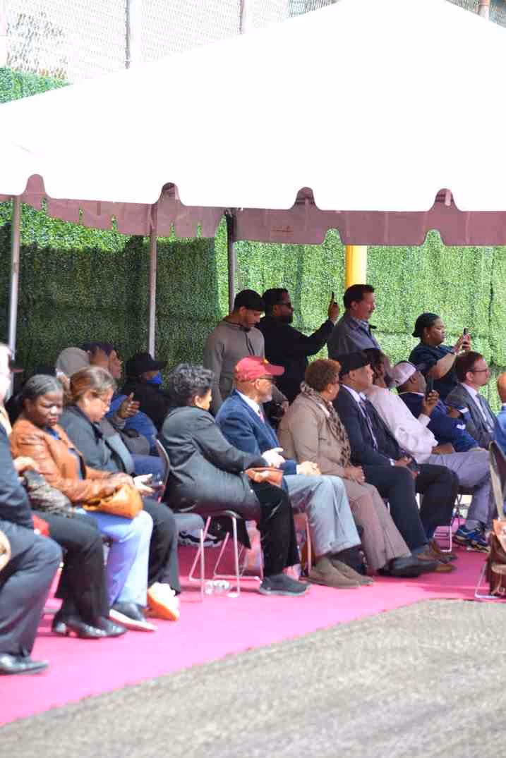 Guests seated under tent at outdoor school ceremony